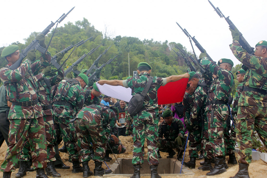 Prajurit TNI saat menembak salvo sebagai penghormatan militer pada upacara pemakaman Sertu Anumerta, Ikrar Setya Nainggolan di Taman Makam Pahlawan (TMP) Tri Jaya Sakti, Kota Sorong, Papua Barat.