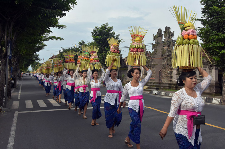 Sejumlah perempuan Bali mengusung Gebogan atau sesajen berisi buah, kue, bunga dan hiasan janur dalam tradisi Mapeed yaitu rangkaian persembahyangan Hari Raya Galungan di Desa Lukluk, Badung, Bali.
