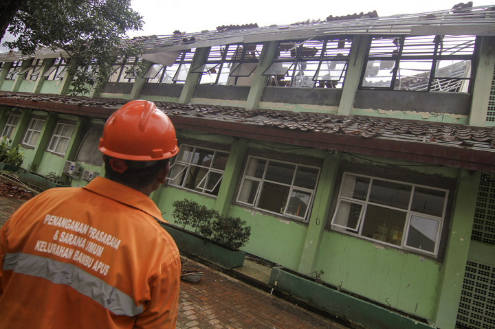 Petugas melihat kondisi ruang kelas yang ambruk di SMKN 24 Bambu Apus, Jakarta Timur, Jumat, 21 Februari 2020.