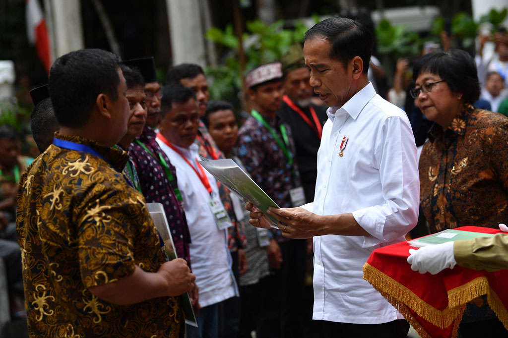 Presiden Joko Widodo didampingi Menteri LHK Siti Nurbaya (kanan) menyerahkan Surat Keputusan (SK) Perhutanan Sosial di Taman Hutan Raya Sultan Syarif Hasyim, Kabupaten Siak, Provinsi Riau, Jumat, 21 Februari 2020.