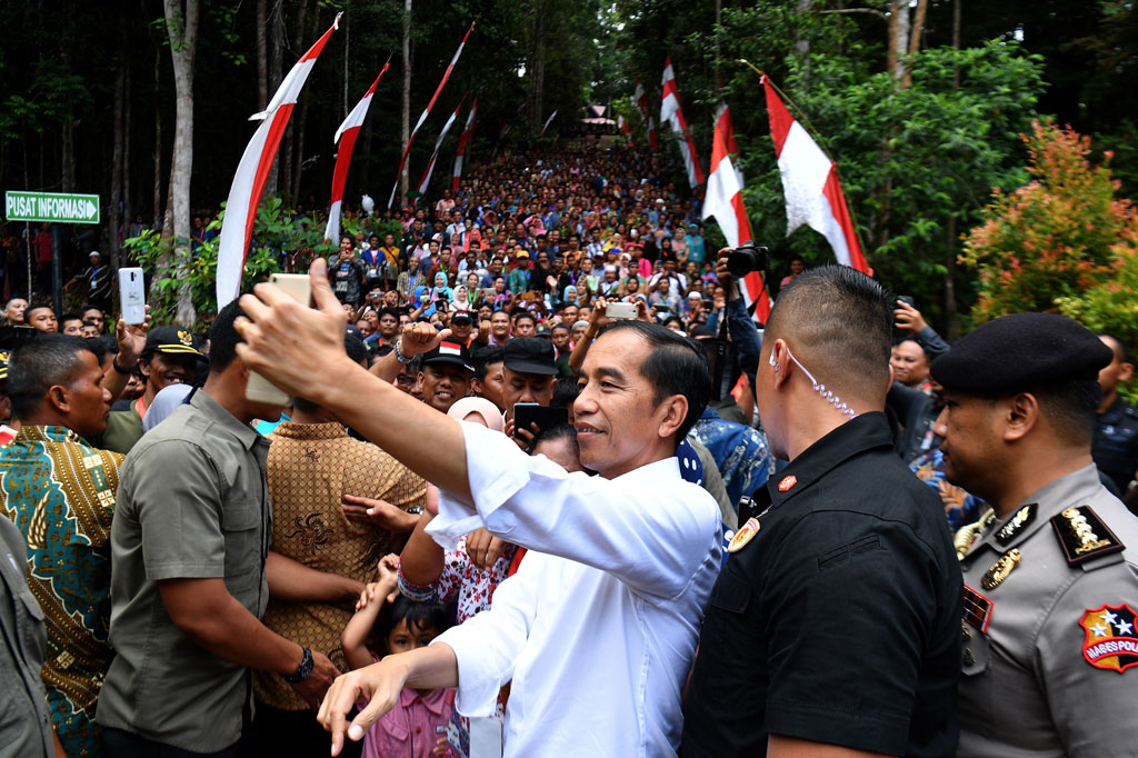 Jokowi melakukan swafoto bersama warga seusai menyerahkan SK Perhutanan Sosial di Taman Hutan Raya Sultan Syarif Hasyim, Kabupaten Siak, Provinsi Riau.
