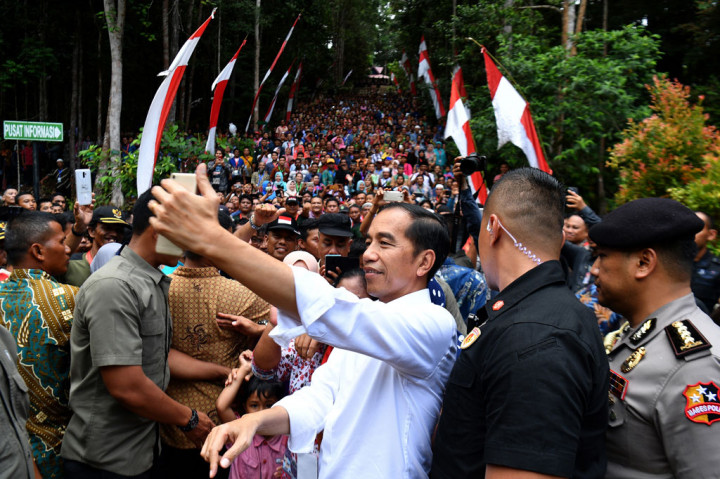 Jokowi melakukan swafoto bersama warga seusai menyerahkan SK Perhutanan Sosial di Taman Hutan Raya Sultan Syarif Hasyim, Kabupaten Siak, Provinsi Riau.