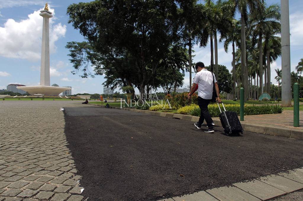 Penampakan uji coba pengaspalan sebagai persiapan gelaran Formula E di kawasan Monas, Jakarta, Sabtu, 22 Februari 2020. Pengaspalan dilakukan di area jalan yang terbuat dari coblestone atau batu alam. 