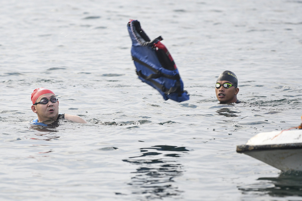 Petugas melemparkan pelampung untuk menolong salah satu peserta yang mengalami kram saat mengikuti Palembang Triathlon 2020 di kategori kelompok umur di Jakabaring Sport City (JSC), Palembang, Sumatera Selatan.