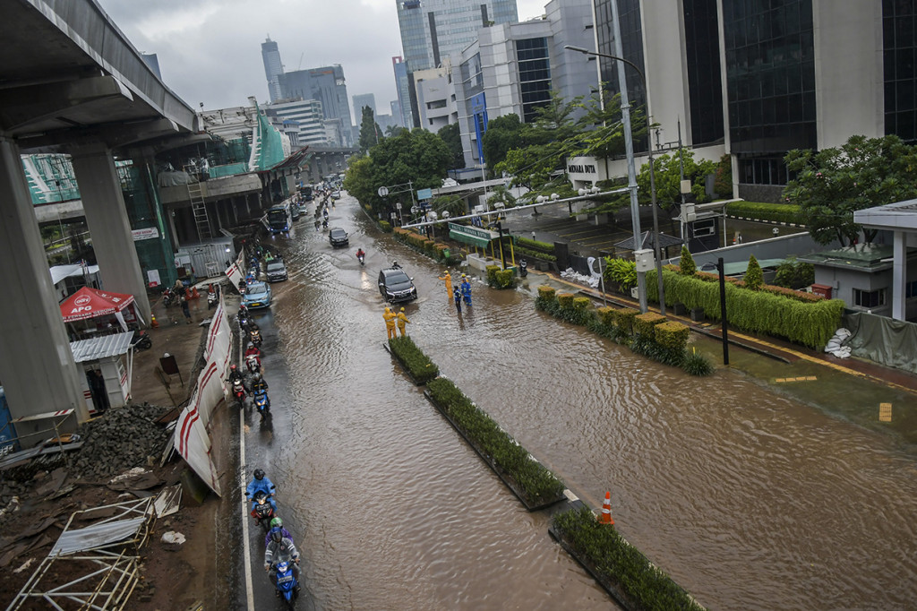Kendaraan melintasi banjir yang menggenangi di Jalan H. R. Rasuna Said, Kuningan, Jakarta, Selasa. ANTARA FOTO/Galih Pradipta