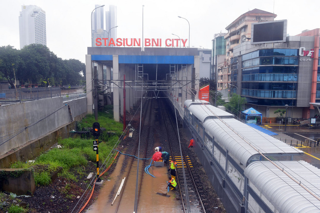 Sejumlah petugas menyedot air dengan pompa yang merendam bantalan rel di Stasiun BNI City, Jakarta. ANTARA FOTO/M Risyal Hidayat