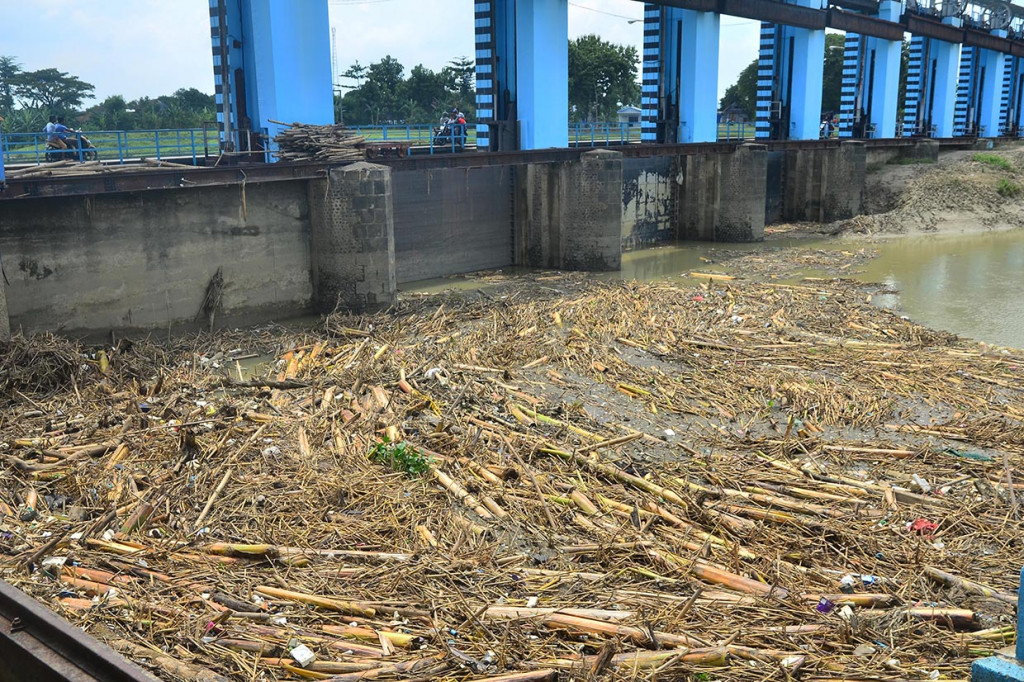 Warga beraktivitas di dekat tumpukan sampah di pintu air Bendungan Wilalung, Undaan, Kudus, Jawa Tengah. 