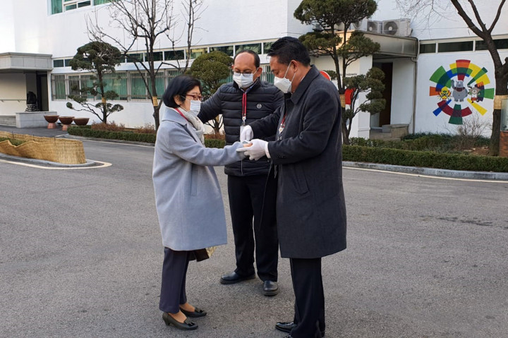 Petugas memeriksa suhu tubuh seorang seorang perempuan di luar Kantor KBRI Seoul dan IIPC Seoul, Korea Selatan, Jumat, 28 Februari 2020.