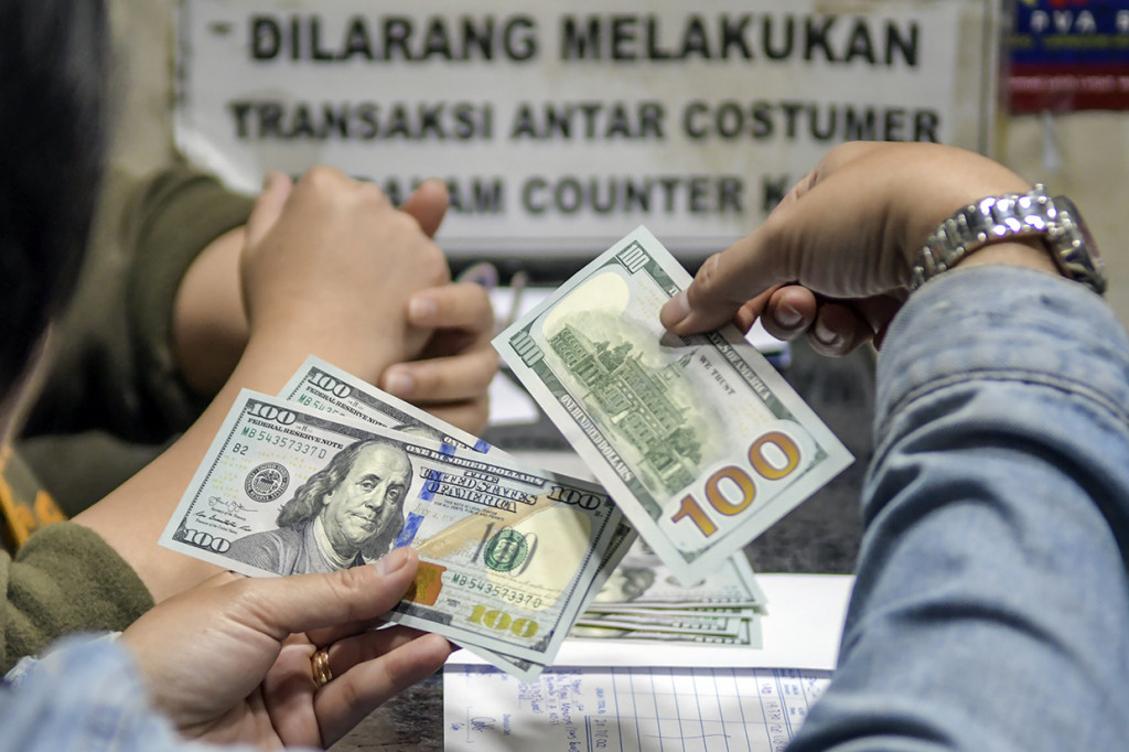 Warga menukarkan mata uang dolar AS di sebuah gerai money changer, Jakarta, Jumat, 28 Februari 2020. 