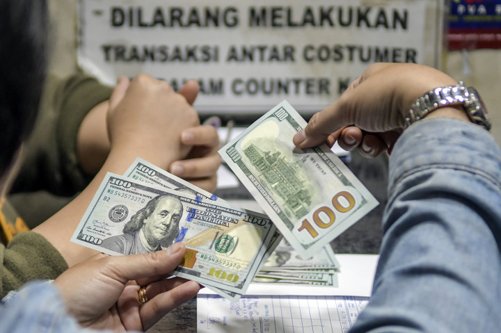 Warga menukarkan mata uang dolar AS di sebuah gerai money changer, Jakarta, Jumat, 28 Februari 2020. 