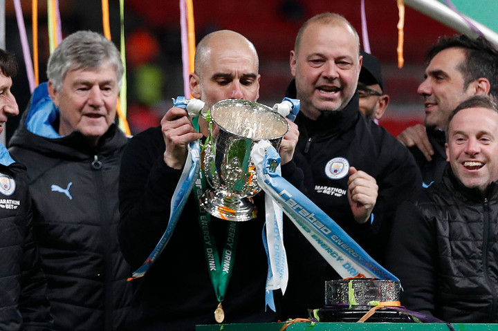 Manajer Manchester City Pep Guardiola mencium trofi Piala Liga Inggris yang baru saja diraih timnya.