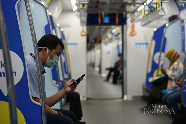 Penumpang menggunakan masker saat memasuki terminal kereta Mass Rapid Transit (MRT) di Stasiun Lebak Bulus Jakarta.
