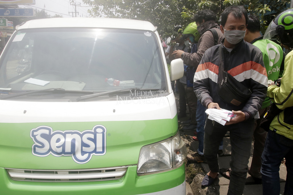 Warga antre berebut membeli masker murah di mobil produsen masker yang keliling di Jalan Tole Iskandar, Depok, Jawa Barat.
