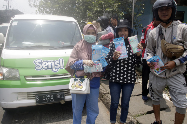 Warga menunjukkan masker yang dibeli dari mobil masker yang keliling di kawasan Kota Depok.
