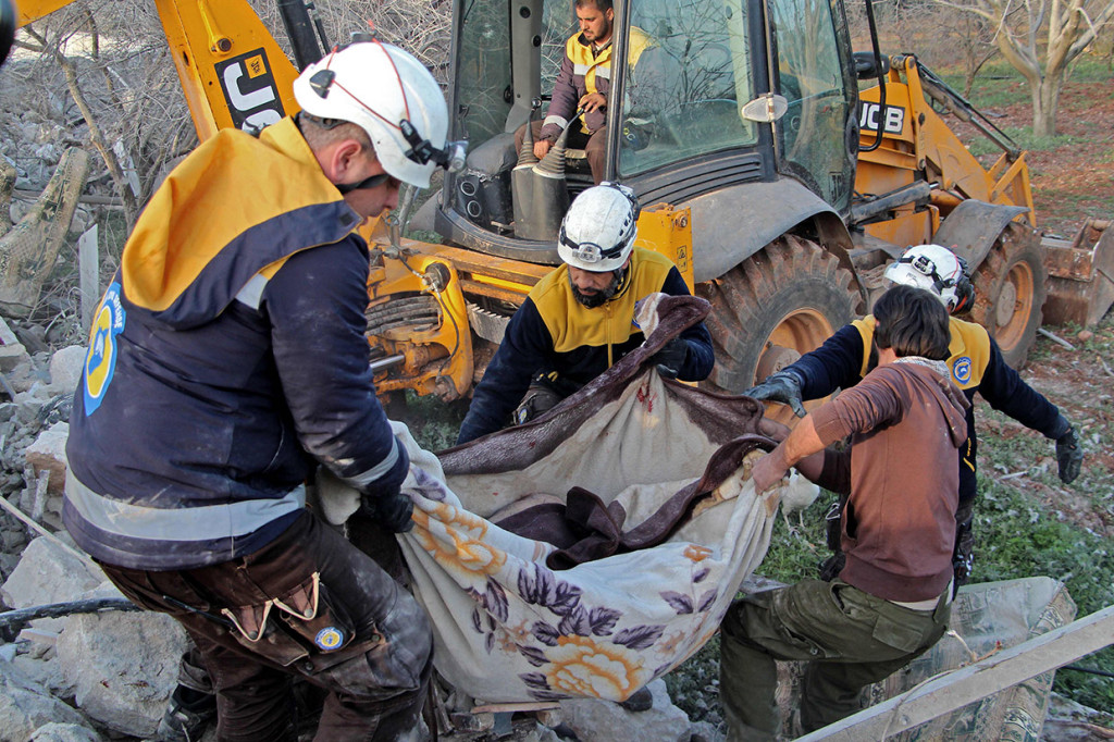Personel Syrian Civil Defence yang juga dikenal 'White Helmets' mengevakuasi jenazah korban serangan udara Rusia di Maaret Misrin, Idlib, barat laut Suriah, Kamis, 5 Maret 2020.