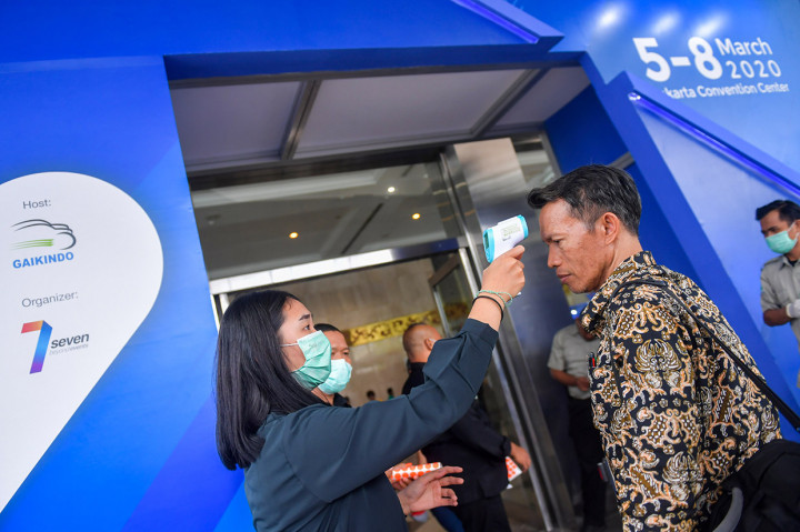 Petugas memeriksa suhu tubuh dari pengunjung pameran kendaraan komersial, Gaikindo Indonesia International Commercial Vehicle Expo (GIICOMVEC) di Jakarta Convention Center, Jakarta Pusat.
