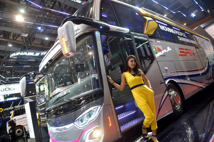 Seorang model berpose di samping bus yang dipamerkan di pameran kendaraan komersial, Gaikindo Indonesia International Commercial Vehicle Expo (GIICOMVEC) di Jakarta Convention Center, Jakarta Pusat.