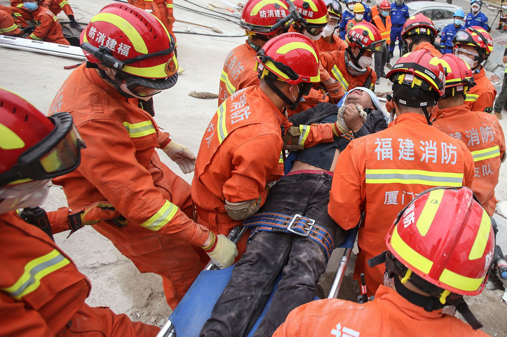 Seorang pria diselamatkan dari puing-puing sebuah hotel yang runtuh di Quanzhou, di provinsi Fujian.
