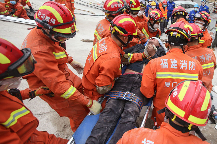 Seorang pria diselamatkan dari puing-puing sebuah hotel yang runtuh di Quanzhou, di provinsi Fujian.
