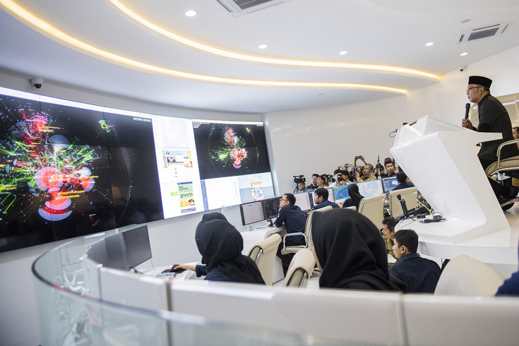 Gubernur Jawa Barat Ridwan Kamil (kanan) memantau grafik informasi penyebaran Covid-19 di Command Center dan Pusat Informasi dan Koordinasi Covid-19 di Bandung, Jawa Barat.