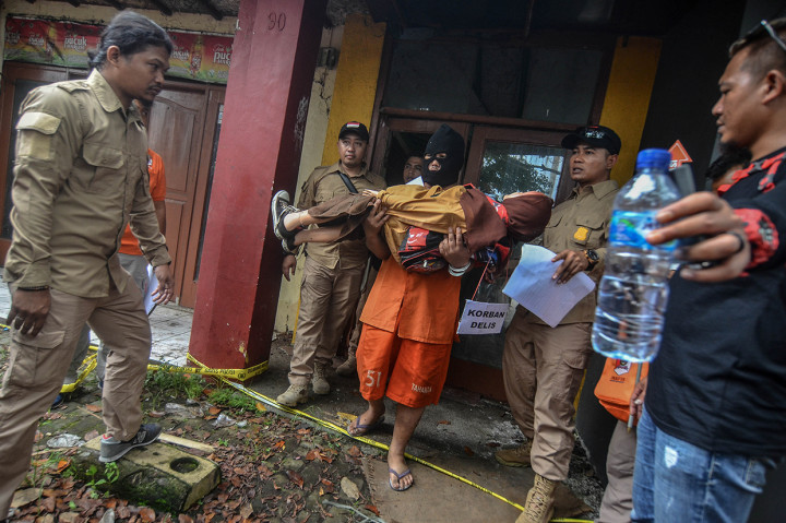 Tersangka Budi Rahmat memperagakan reka ulang pembunuhan kepada anaknya sendiri pada rekontruksi di Cilembang, Kota Tasikmalaya, Jawa Barat.