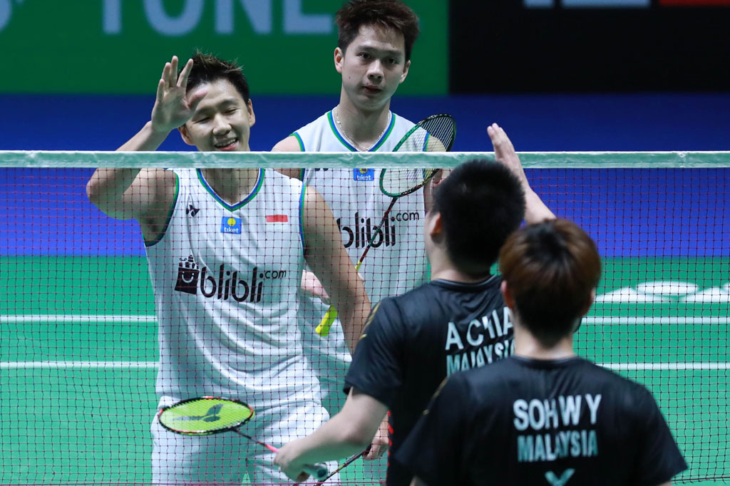 Pebulu tangkis ganda putra Indonesia Marcus Fernaldi Gideon (kiri) dan rekannya Kevin Sanjaya Sukamuljo  bersalaman dengan lawannya asal Malaysia Aaron Chia dan Soh Wooi Yik usai menang dalam babak perempat final All England Open 2020 di Arena Birmingham, Inggris, Jumat, 13 Maret 2020. 