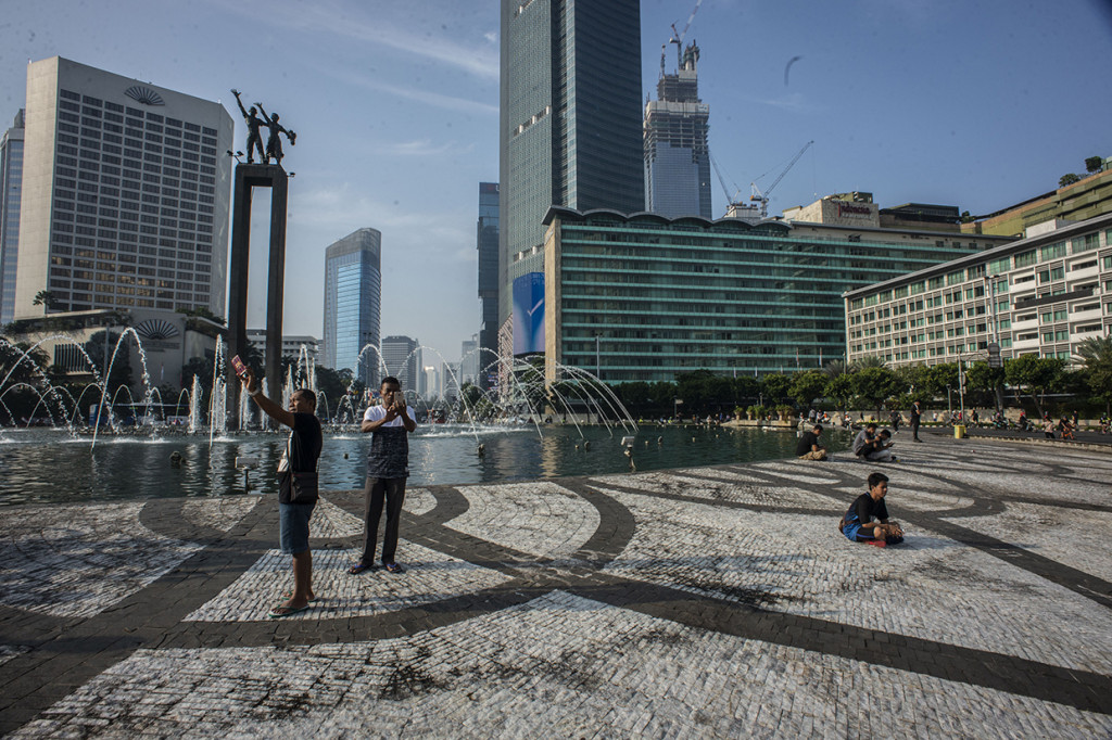 Sejumlah warga beraktivitas di kawasan Bundaran HI, Jakarta. 
