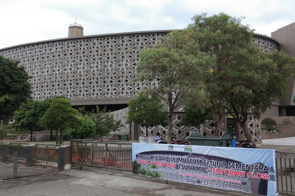 Sebuah banner pemberitahuan tutup sementara  terpasang di depan Museum Tsunami Aceh.