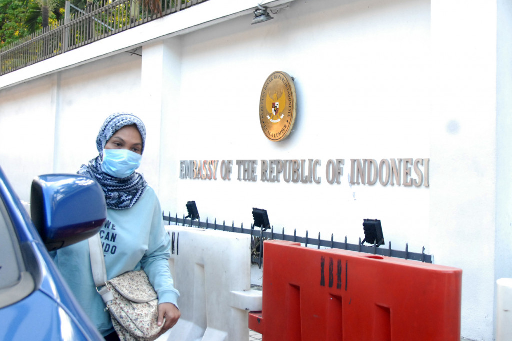 Seorang WNI berjalan di depan kantor Kedutaan Besar Republik Indonesia (KBRI) di Kuala Lumpur, Malaysia. 