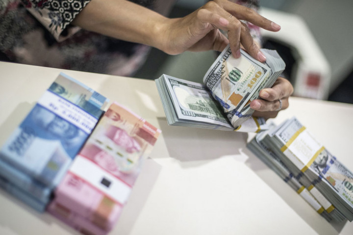 Karyawan menghitung uang dolar AS di Kantor Cabang Plaza Mandiri, Jakarta, Rabu, 18 Maret 2020.