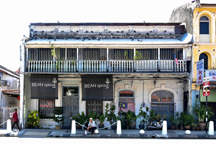 Seorang pria duduk di depan restoran yang telah tutup saat hari pertama kebijakan lockdown di Malaysia.
