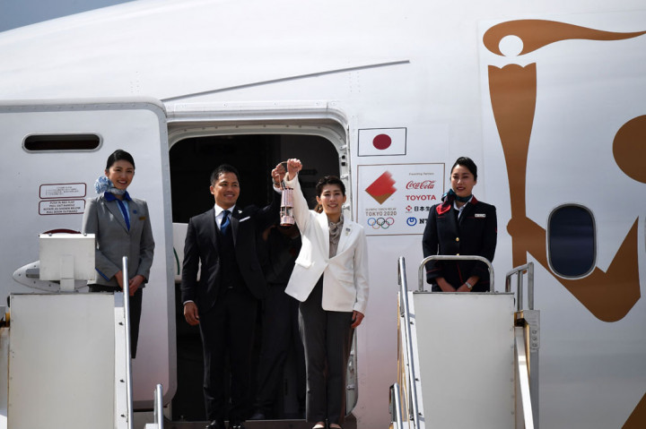 Atlet Jepang peraih tiga medali emas olimpiade Tadahiro Nomura dan Saori Yoshida bertindak sebagai penjemput api olimpiade dari dalam pesawat, saat tiba di JASDF Pangkalan Udara Matsushima, Higashimatsushima, Prefektur Miyagi.