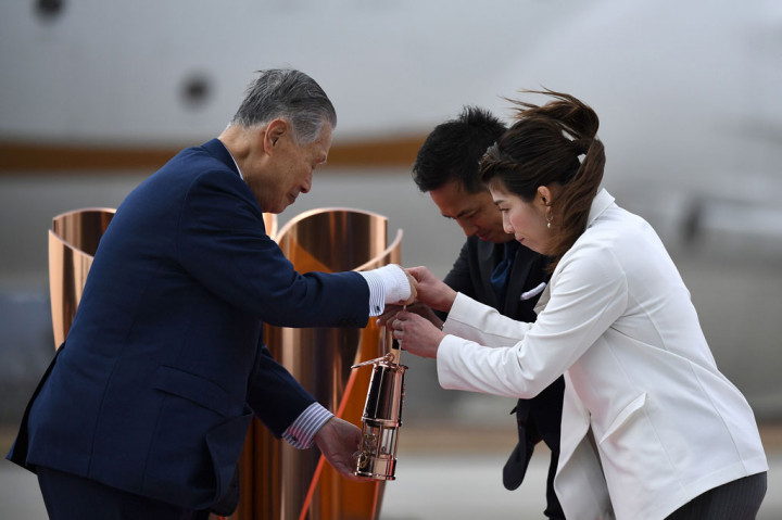 Tadahiro Nomura dan Saori Yoshida secara simbolis kemudian melakukan serah terima api tersebut kepada Presiden Olimpiade 2020 Yoshiro Mori.