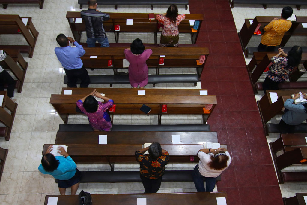 Umat Katolik melaksanakan ibadah misa harian dengan menjaga jarak (social distancing) di Gereja Maria Ratu Damai, Banyuwangi, Jawa Timur, Jumat, 20 Maret 2020. 