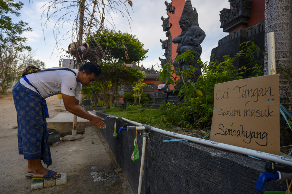 Seorang umat Hindu mencuci tangan sebelum melakukan ritual persembahyangan di Pura Agung Jagatnatha Wana Kertha, Palu, Sulawesi Tengah.