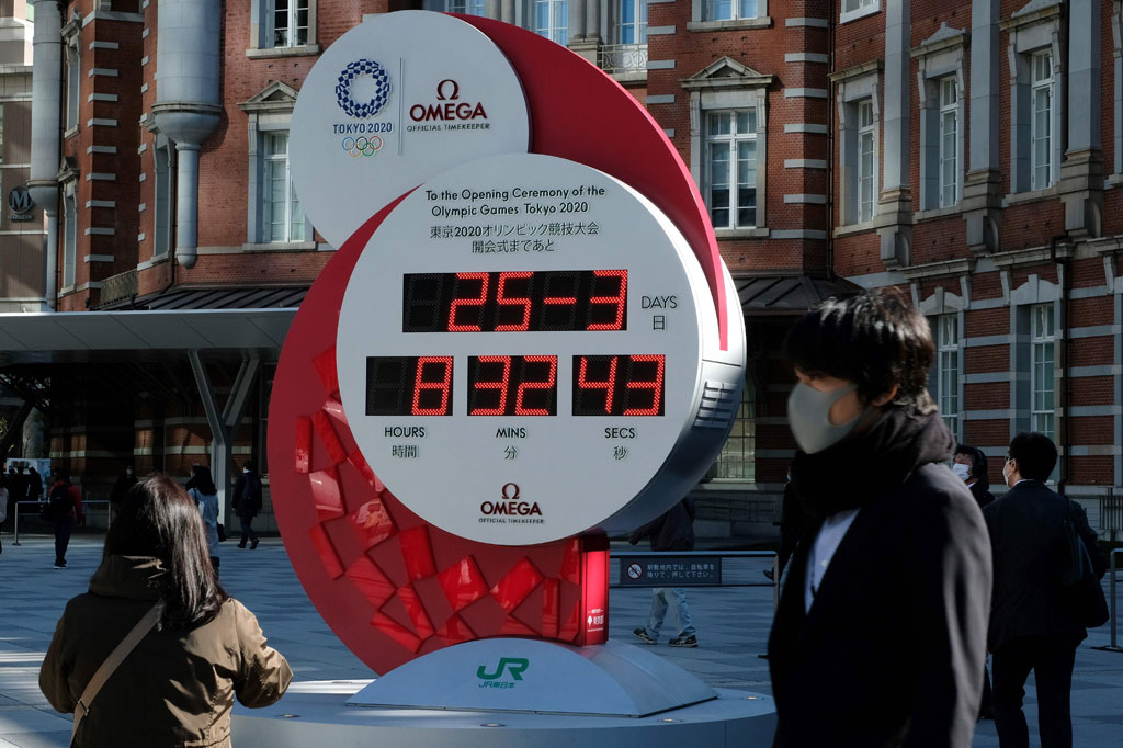 Warga mengambil gambar ketika jam hitung mundur itu berhenti menayangkan angka-angka hari sampai Olimpiade digelar, setelah Olimpiade Tokyo ditunda karena pandemi virus korona atau covid-19.