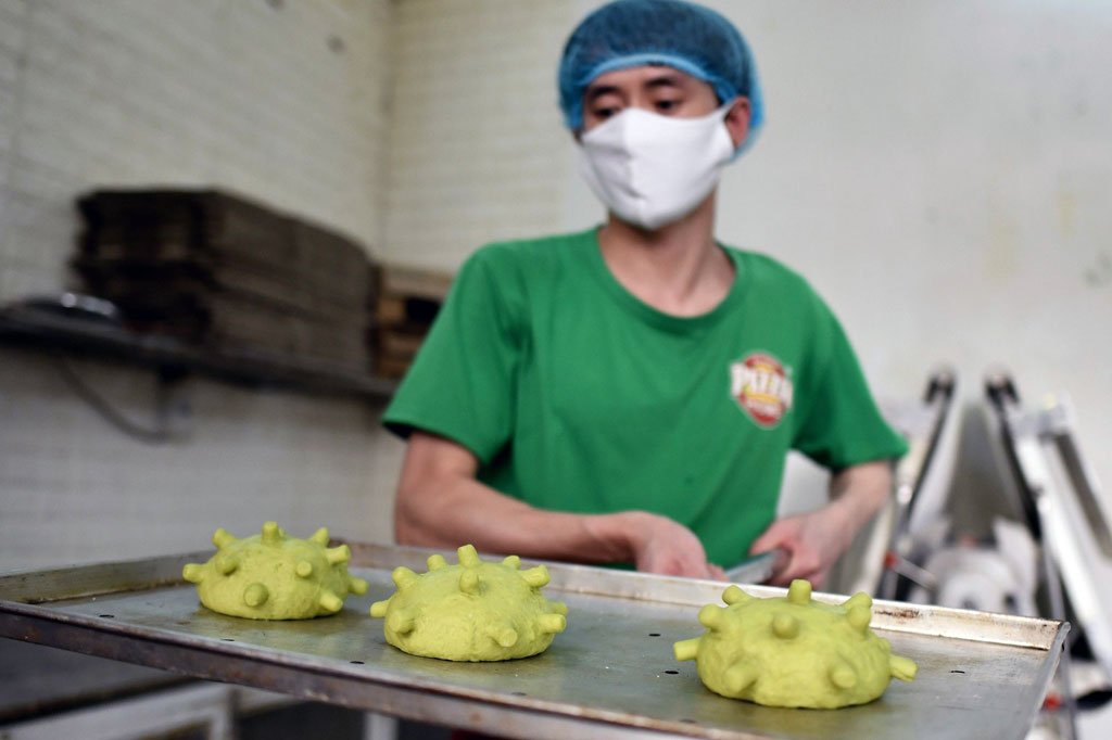 Pemilik toko roti Pizza Home, Hoang Tung memperlihatkan burger ciptaannya yang bertema coronavirus di Hanoi, Kamis, 26 Maret 2020.