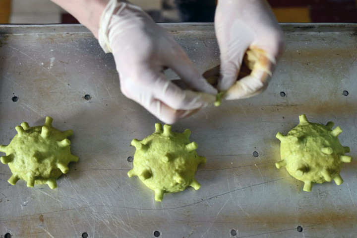 Menghadapi pandemi global, koki Hoang Tung dan timnya menghabiskan hari-hari mereka untuk mencetak puluhan roti bernoda teh hijau lengkap dengan mahkota-mahkota kecil yang terbuat dari adonan menyerupai gambar mikroskopis virus tersebut.