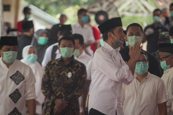 Presiden Joko Widodo menyapa pelayat usai mengikuti prosesi pemakaman di komplek pemakaman keluarga Dukuh Mandu, Desa Nolligaten, Gondangrejo, Karanganyar, Jawa Tengah.