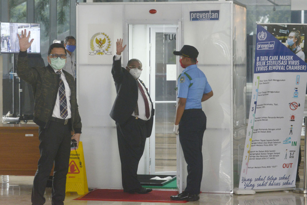 Ketua Komisi II Ahmad Doli Kurnia dan anggota DPR Aboe Bakar Al-Habsyi antri masuk dalam Box Disinfektan sebelum Rapat Paripurna untuk membuka masa sidang di tengah wabah virus covid-19.