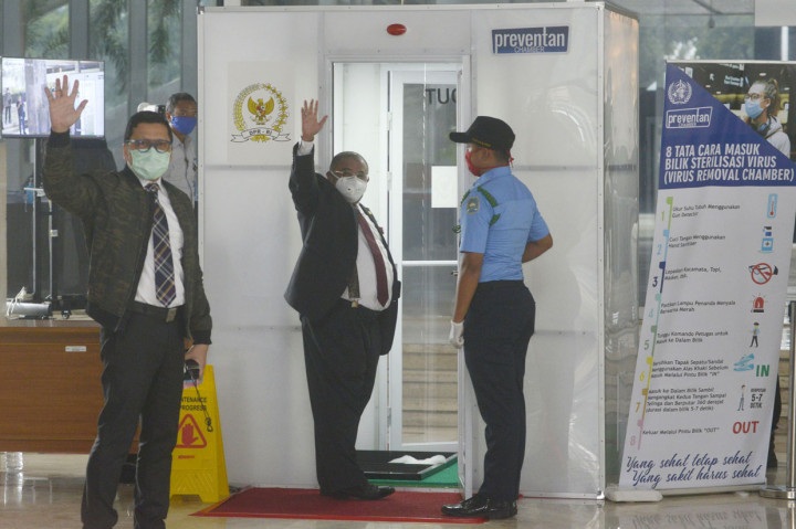 Ketua Komisi II Ahmad Doli Kurnia dan anggota DPR Aboe Bakar Al-Habsyi antri masuk dalam Box Disinfektan sebelum Rapat Paripurna untuk membuka masa sidang di tengah wabah virus covid-19.