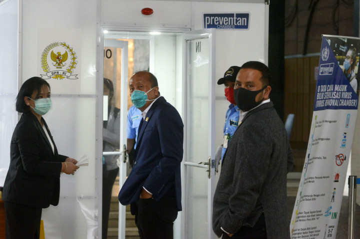 Angota DPR Fraksi NasDem yang juga Sekretaris Fraksi NasDem DPR, Saan Mustopa antri masuk dalam Box Disinfektan sebelum Rapat Paripurna untuk membuka masa sidang di tengah wabah virus covid-19.