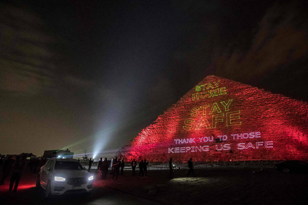'Tetap aman', 'Tetap di rumah' dan 'Terima kasih kepada mereka yang membuat kita aman', muncul dengan cahaya biru dan hijau di seluruh struktur piramida yang menjulang di dataran tinggi Giza, barat daya ibu kota Kairo.