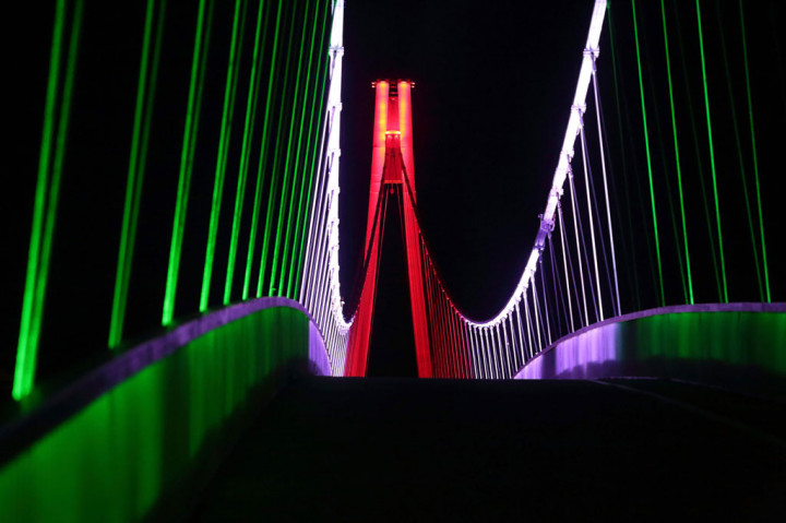 Jembatan penyeberangan di Sungai Drava di Kota Osijek, Kroasia diterangi dengan warna bendera nasional Italia dalam upaya mendukung Italia melawan virus korona (covid-19).
