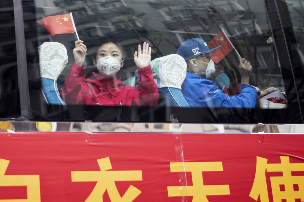 Tenaga medis bantuan di Wuhan melambaikan tangan saat akan pulang ke daerah masing-masing.
