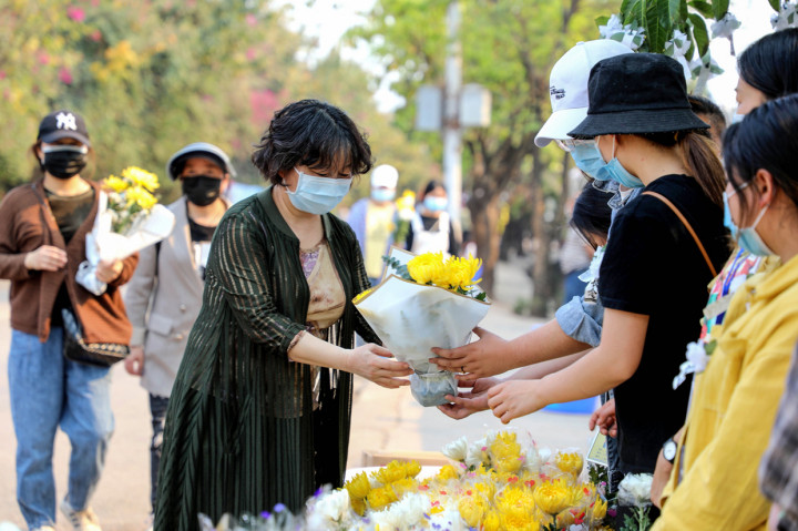 Seorang wanita meletakkan bunga di pemakaman Xichang, Provinsi Sichuan, Tiongkok.