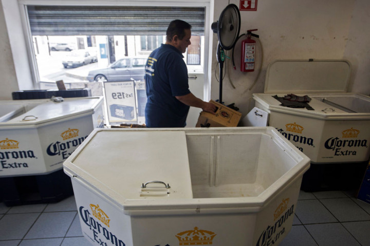 Seorang pekerja berada di dalam toko di antara kulkas bir Corona yang telah kosong di Monterrey,  Nuevo Leon, Meksiko, Jumat, 3 April 2020 waktu setempat.