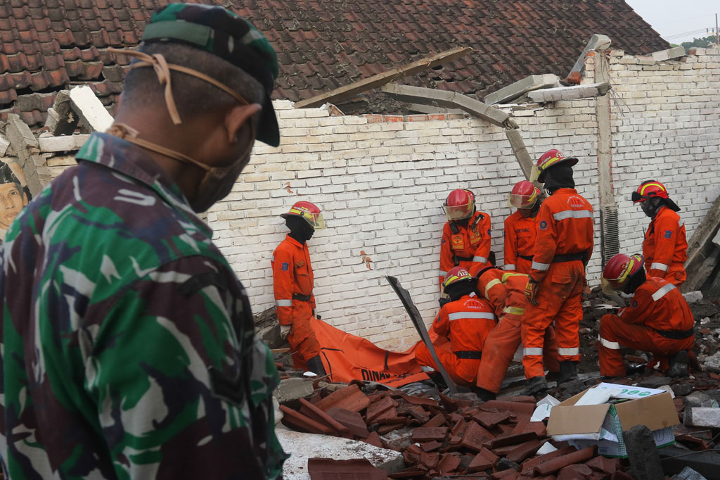 Petugas mengevakuasi jenazah korban yang tertimpa reruntuhan bangunan rumah di Jalan Ketintang Barat Gang II, Surabaya, Jawa Timur, Sabtu, 4 April 2020.
