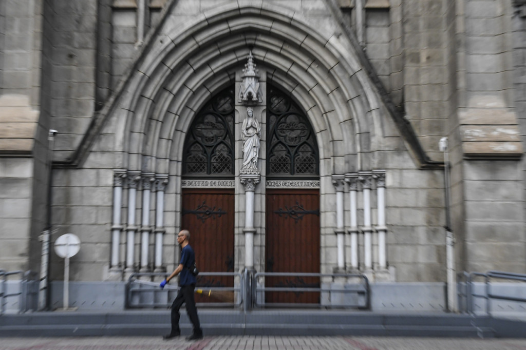 Petugas kebersihan melintas di depan pintu Gereja Katedral, Jakarta, Minggu, 5 April 2020.
