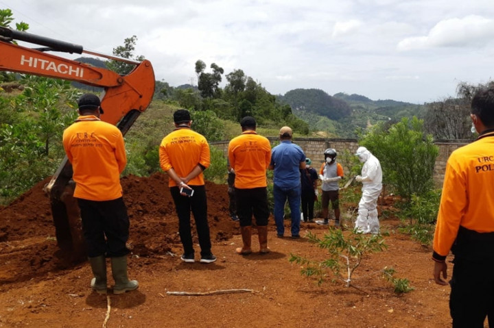 Para petugas kesehatan dari Rumah Sakit Dian Harapan, Abepura, Papua saat melakukan prosesi pemakaman terhadap jenazah covid-19 di Tempat Pemakaman Umum (TPU) Buper, Waena, Kota Jayapura, Papua. 